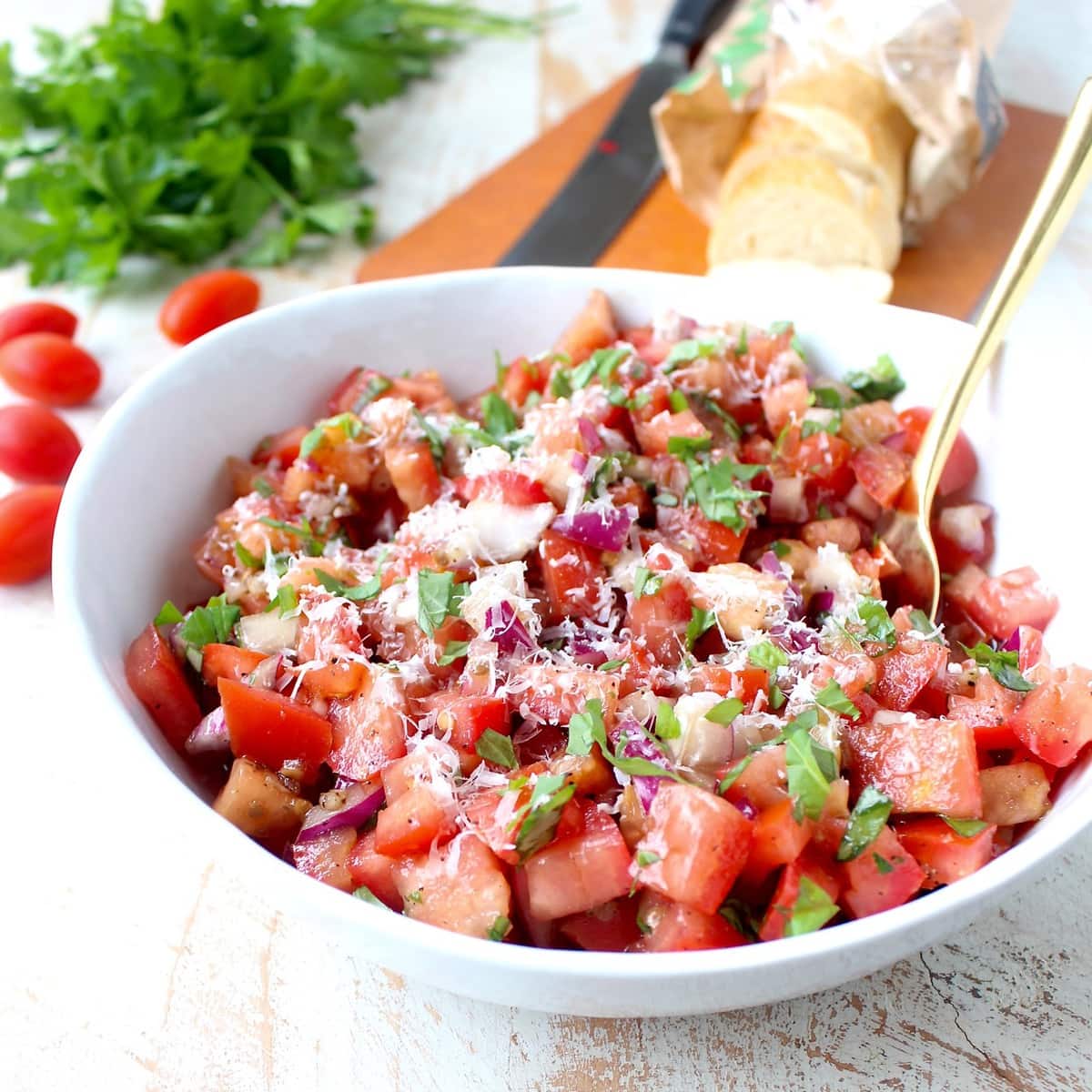 tomato basil bruschetta in bowl with gold spoon