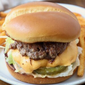 smash burger on plate with fries