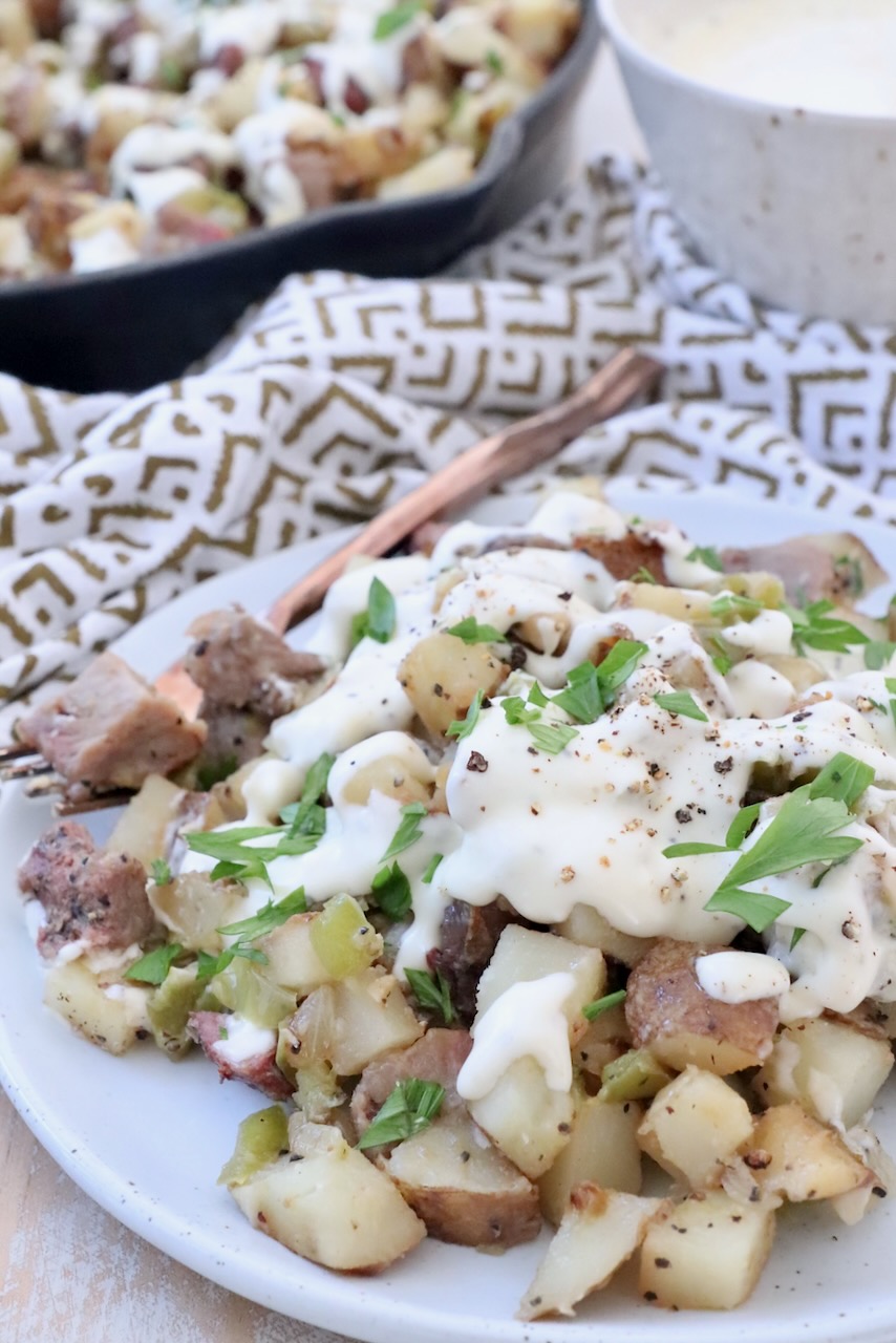 potato hash on plate covered with cheese sauce