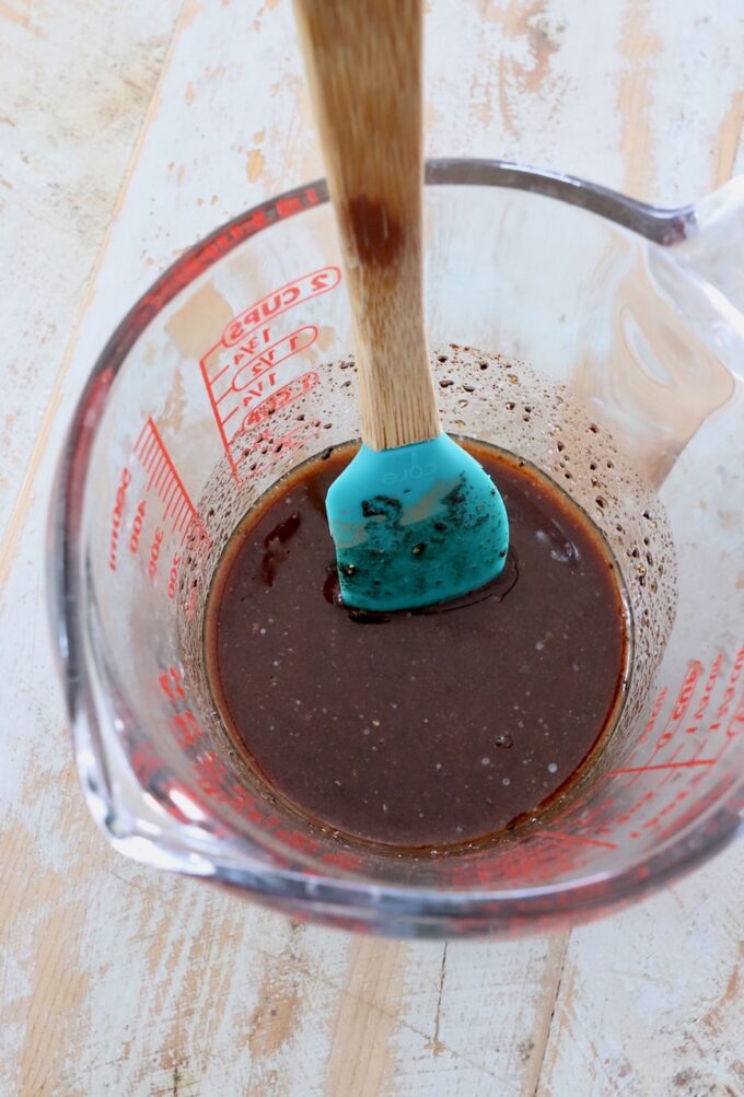 honey butter glaze in glass measuring cup with spatula