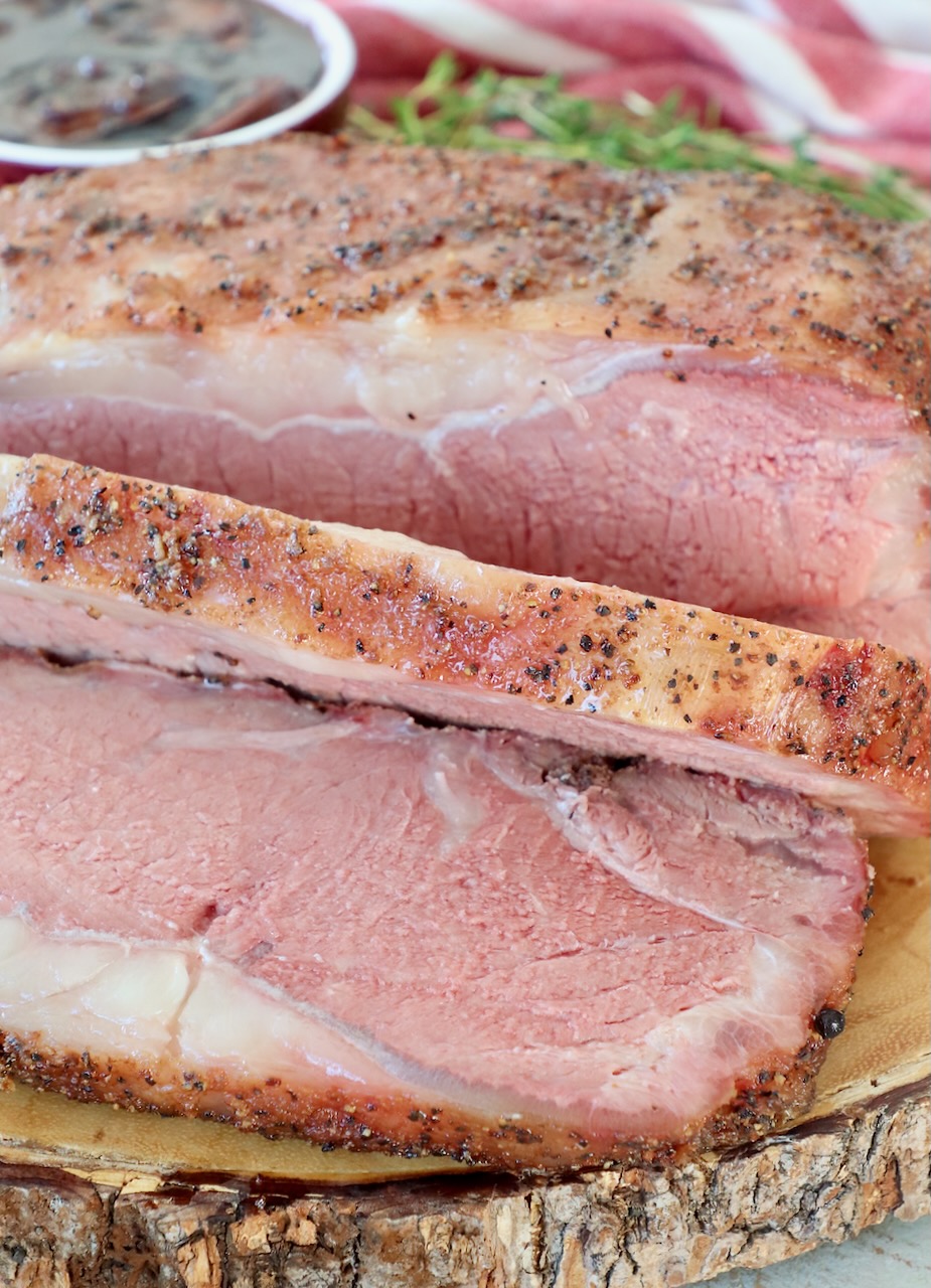 sliced, smoked new york strip roast on wood board